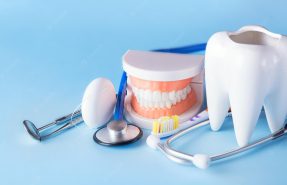 dental-health-teethcare-concept-dental-mirror-with-explorer-probe-toothbrush-floss-human-jaw-model-white-tooth-with-stethoscope-blue-background_136401-4117